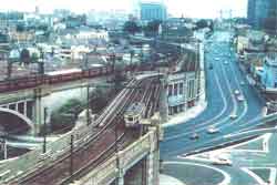 The northern approaches to the Sydney Harbour Bridge in 1957 with trams in the foreground and an electric train on the western approach.